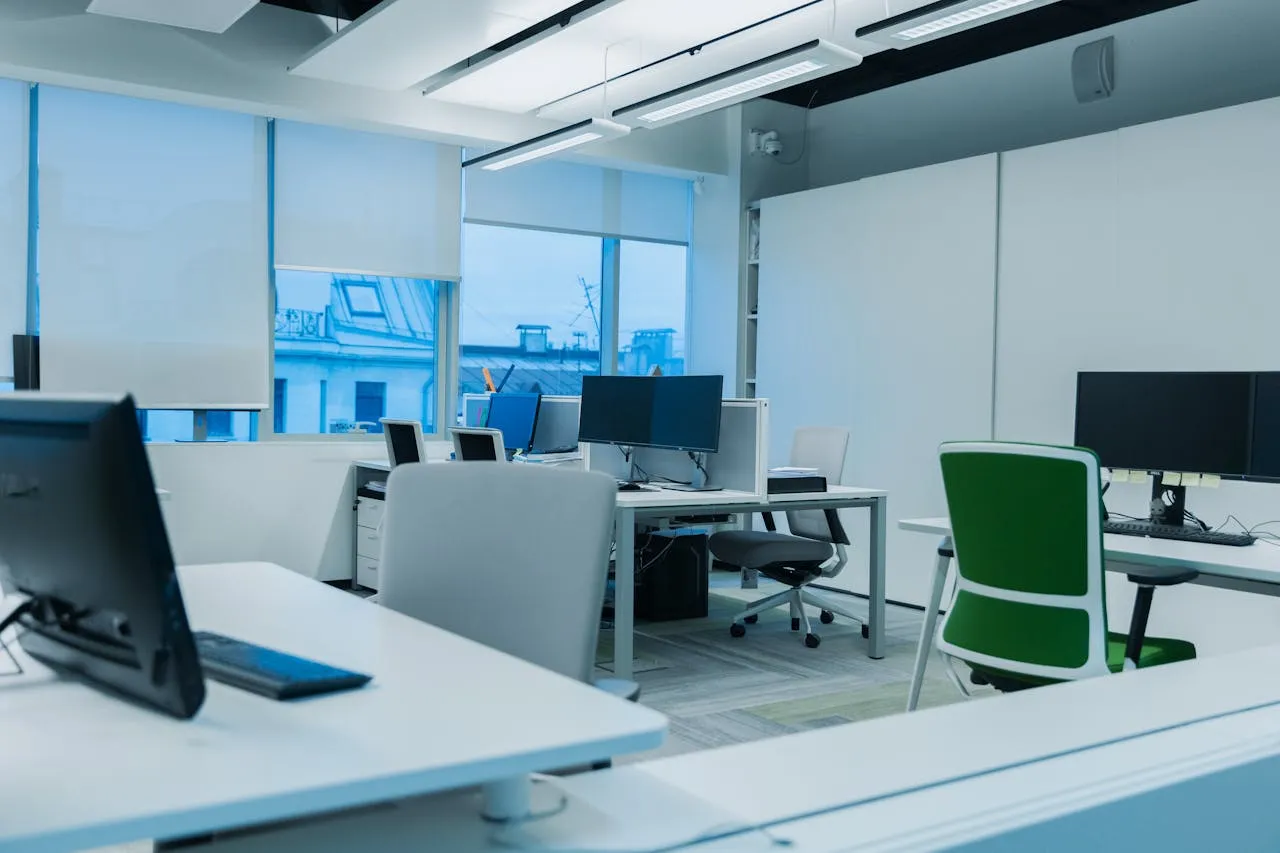 Office desks with monitors and chairs